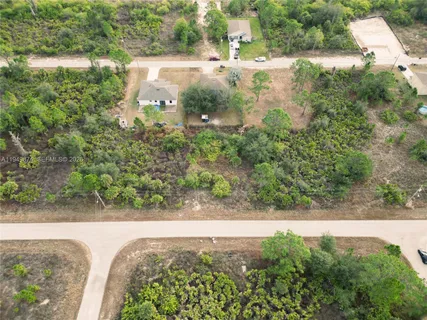 an aerial view of a house with yard and lake view