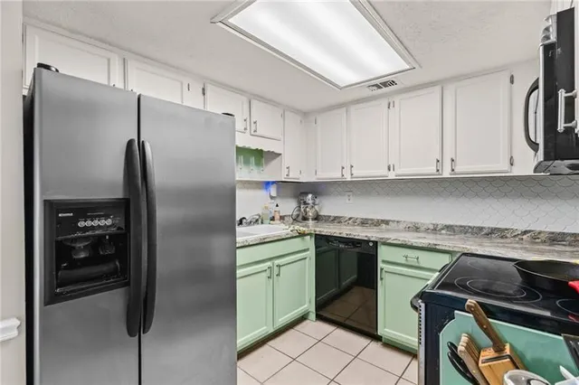 a kitchen with a refrigerator sink and cabinets
