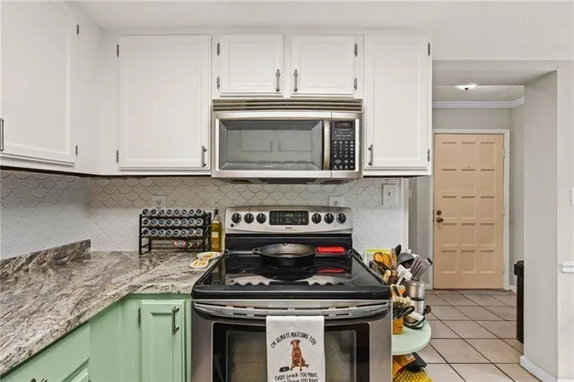 a kitchen with granite countertop a stove top oven microwave and cabinets