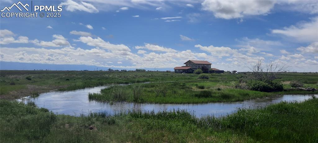 Saguache Creek runs through the property. Here the view is the creek with the gorgeous home in the background.