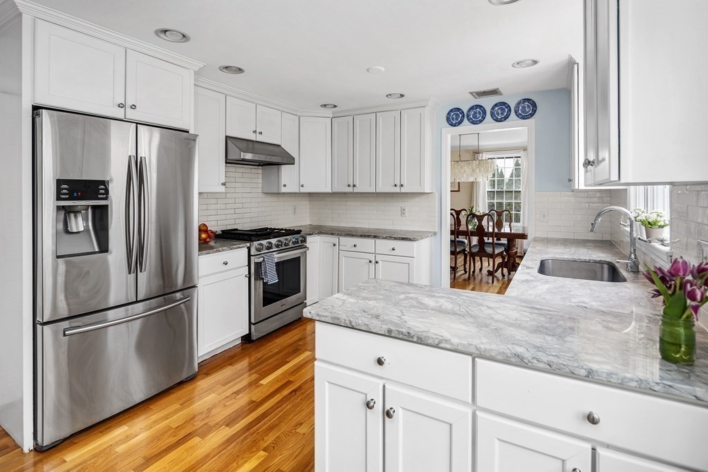 11 Chamberlain Run Hingham, MA 02043 - Photo 3 of 19 a kitchen with granite countertop a refrigerator a stove a sink a counter space and cabinets