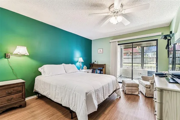 a bedroom with a bed and a flat tv screen on dresser