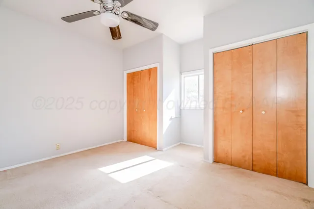 an empty room with closet and windows