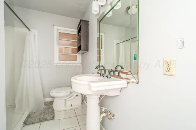 a bathroom with a sink toilet and a mirror