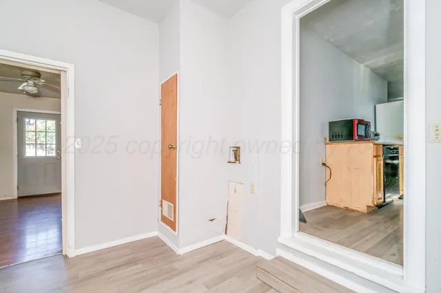 a view of an empty room with wooden floor and closet