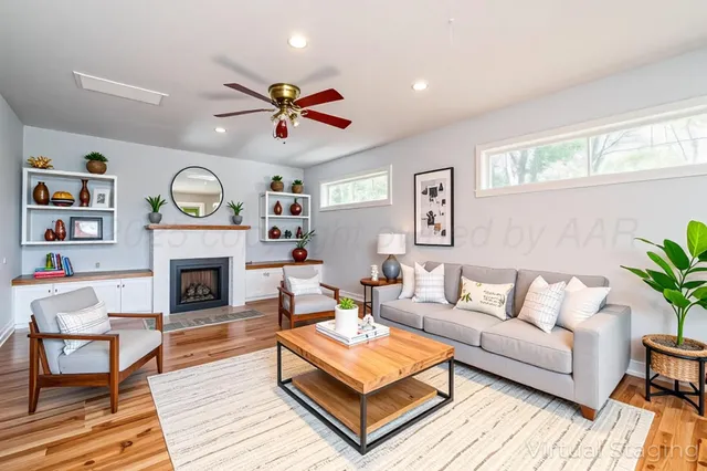 a living room with furniture a clock and a fireplace