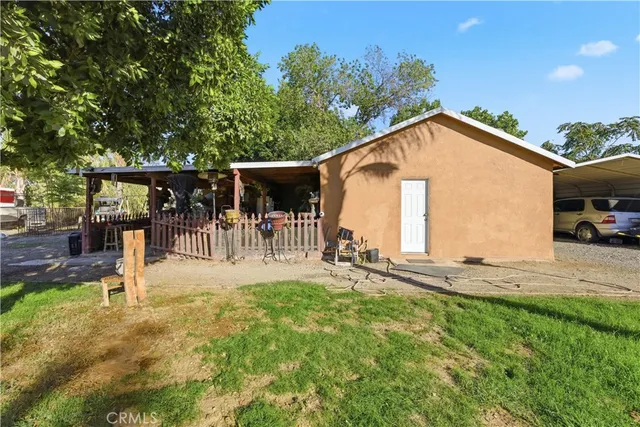 a view of a house with backyard and sitting area