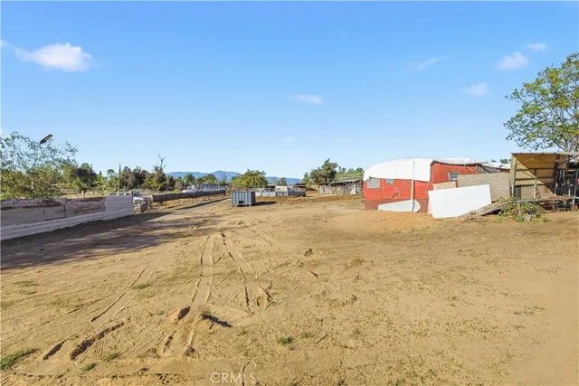 a view of a swimming pool with a yard and palm trees