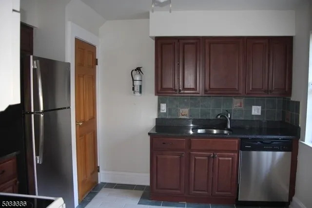 a kitchen with stainless steel appliances granite countertop a refrigerator and a stove