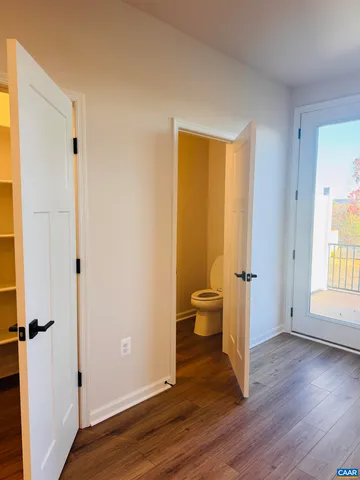 a view of a room with wooden floor closet and windows