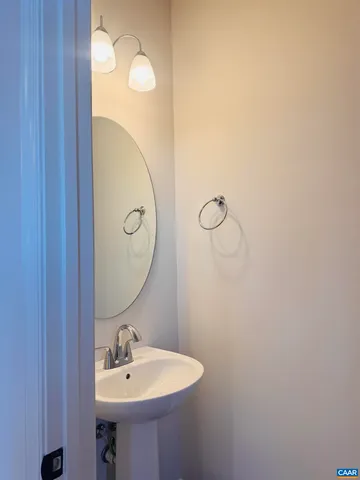 a bathroom with a sink a light fixture and a mirror