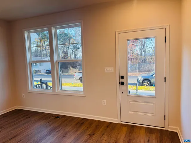an empty room with window and wooden floor