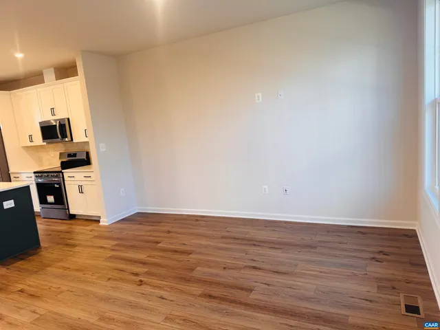 a view of a kitchen with wooden floor and electronic appliances