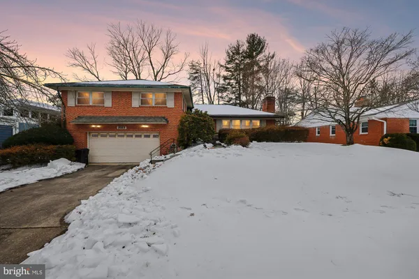 a front view of a house with a yard covered in snow