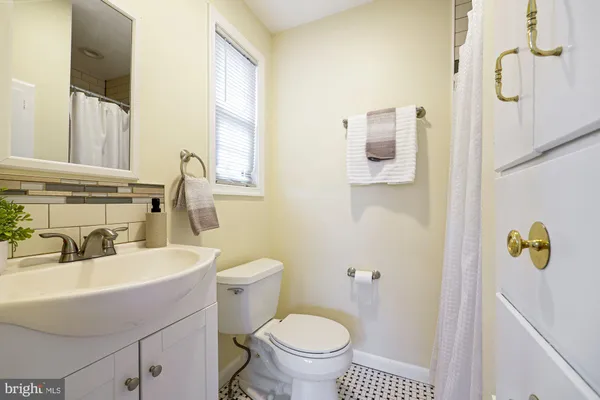a bathroom with a sink toilet and mirror