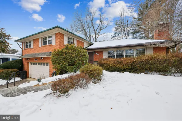 a front view of a house with a yard covered with snow