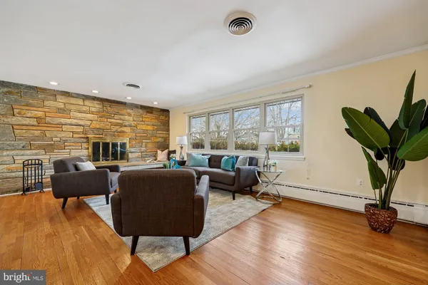 a living room with furniture potted plant wooden floor and a large window
