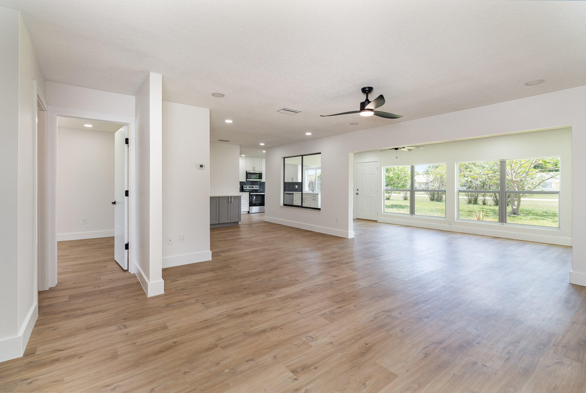 1221 Creel Road Northeast Palm Bay, FL 32905 - Photo 8 of 23 a view of a livingroom with wooden floor and a kitchen