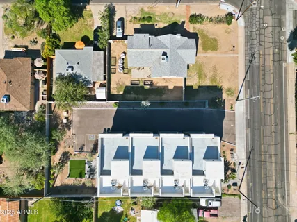 an aerial view of residential houses with outdoor space and street view
