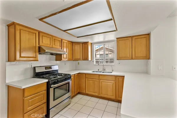 a kitchen with a sink stove top oven and cabinets