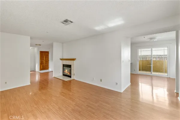an empty room with wooden floor and fireplace