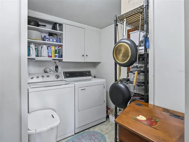 a utility room with dryer washer and a view of living room