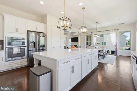 a large kitchen with stainless steel appliances kitchen island granite countertop a large island in the center