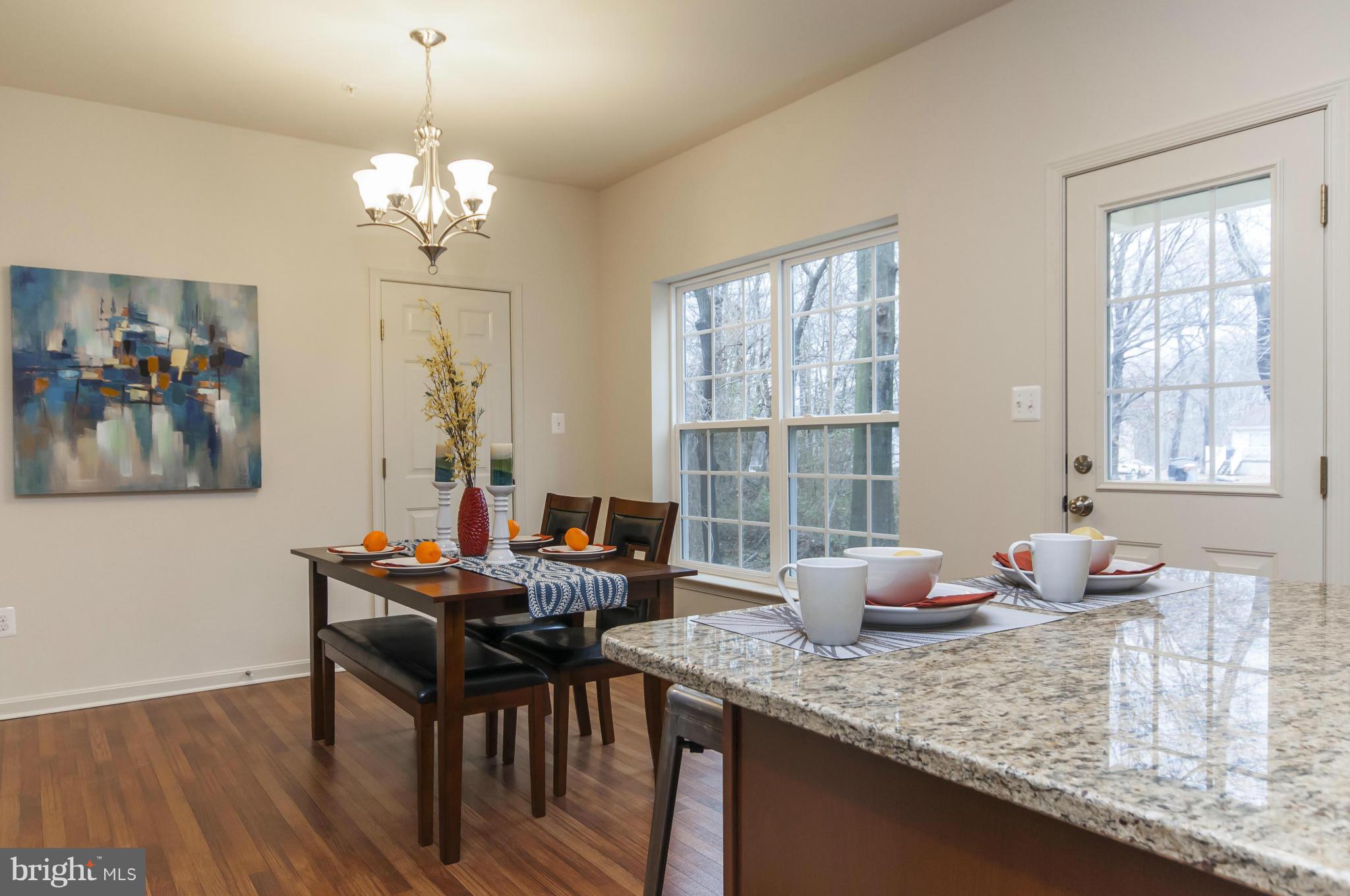 1622 Renaissance Drive Baltimore, MD 21221 - Photo 4 of 20 a dining room with wooden floor a chandelier a wooden table and chairs