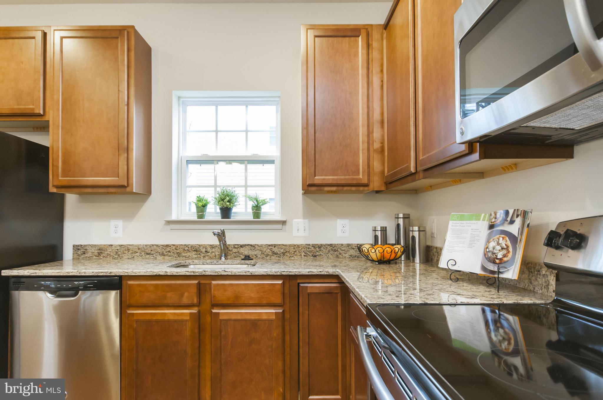 1622 Renaissance Drive Baltimore, MD 21221 - Photo 6 of 20 a kitchen with stainless steel appliances granite countertop a sink a stove and a microwave