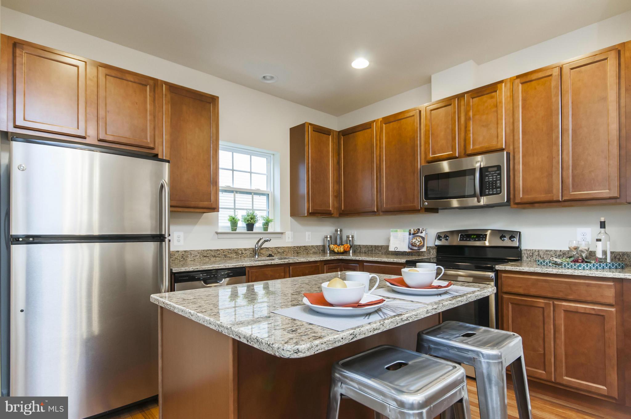 1622 Renaissance Drive Baltimore, MD 21221 - Photo 7 of 20 a kitchen with stainless steel appliances granite countertop a refrigerator stove microwave sink and cabinets