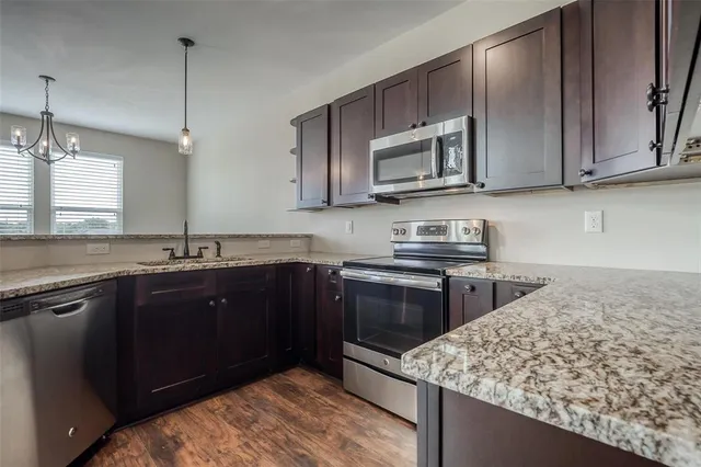a kitchen with stainless steel appliances granite countertop a sink stove and microwave