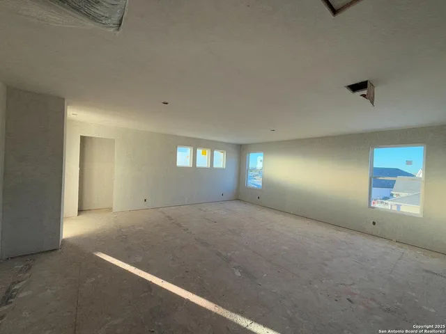 an empty room with a window and fireplace