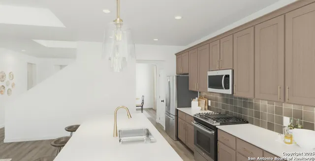 a kitchen with kitchen island granite countertop a sink a stove and a refrigerator