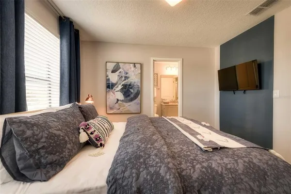 a bedroom with a large bed and a flat screen tv
