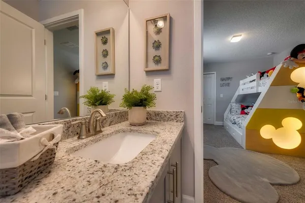 a bathroom with a granite countertop sink and a mirror