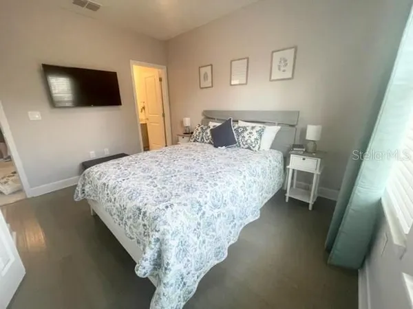 a bedroom with a bed and a flat screen tv