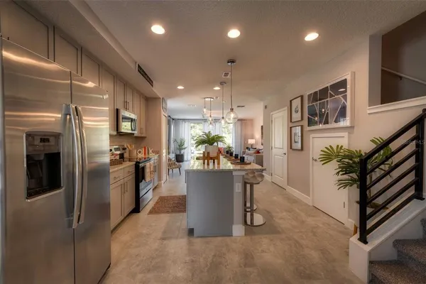 a view of a kitchen with furniture and stainless steel appliances