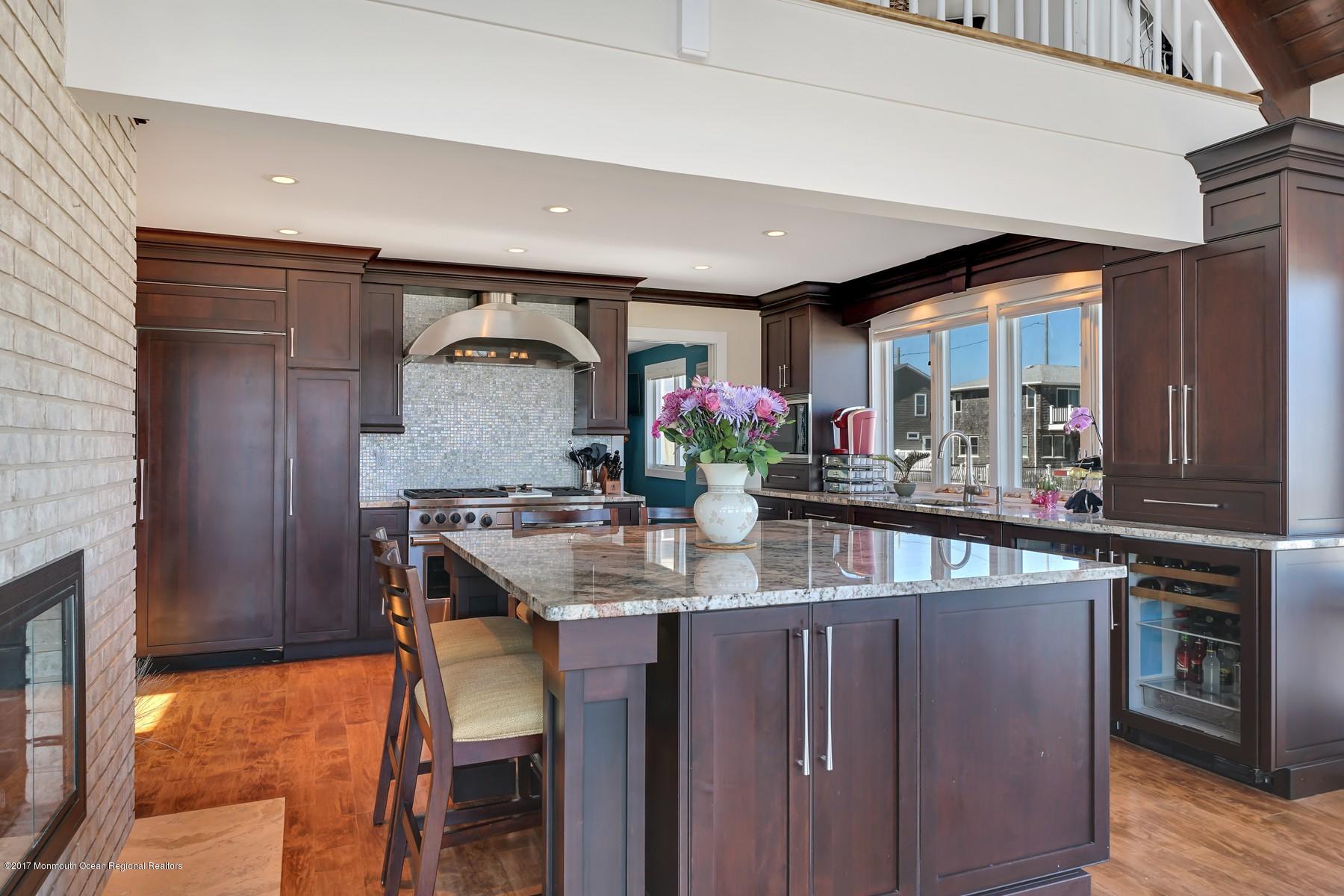 10 East Colony Road Lavallette, NJ 08735 - Photo 14 of 42 a kitchen with kitchen island granite countertop wooden cabinets and a refrigerator