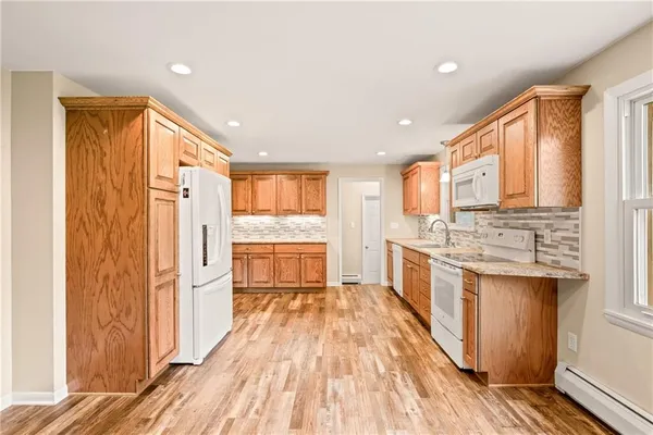 a view of a kitchen with a sink and dishwasher with wooden floor