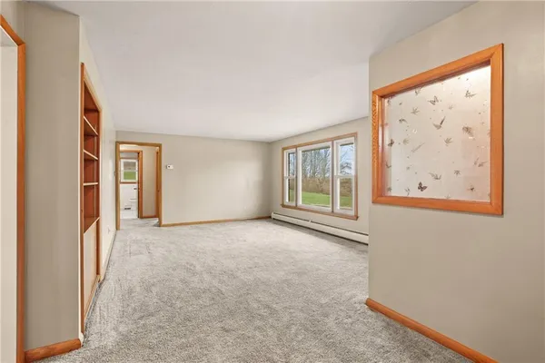 an empty room with cabinet and windows