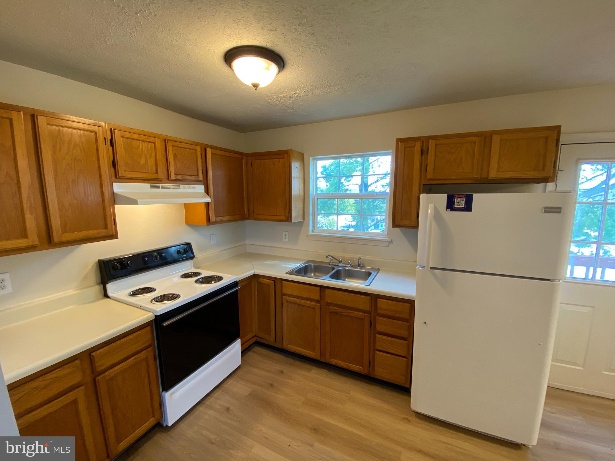 624 Highview Court Culpeper, VA 22701 - Photo 8 of 21 a kitchen with a refrigerator sink and wooden cabinets