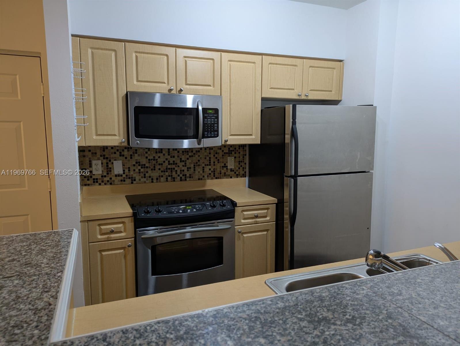 a kitchen with granite countertop a stove and a refrigerator