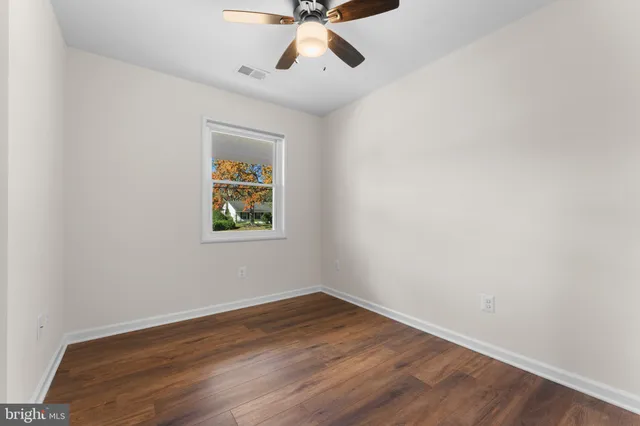 a view of a yard in front of a house with large trees