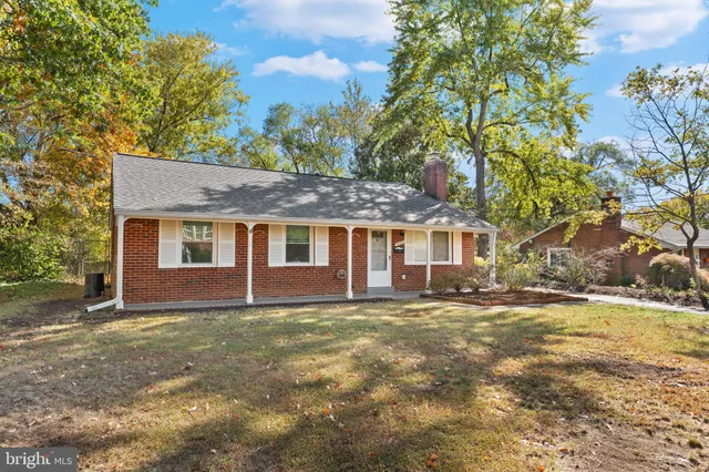 a view of a yard in front of a house with large trees