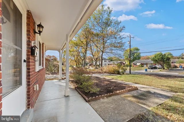a view of an empty room with wooden floor and fireplace