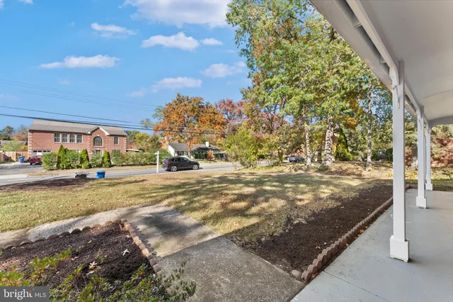 a view of an empty room with wooden floor and window