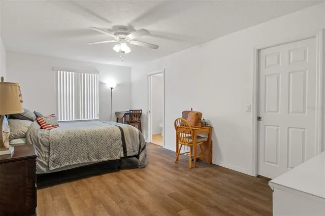 a bedroom with a bed table chair and a chandelier