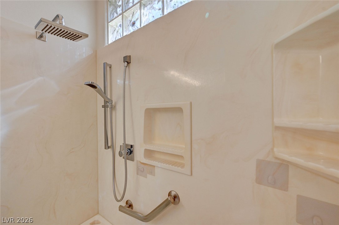 2529 Springville Way Henderson, NV 89052 - Photo 36 of 70 Smooth solid surface walls and modern fixtures accent this sleek walk-in shower space.