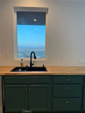 a large kitchen with stainless steel appliances a large counter top a stove and a refrigerator