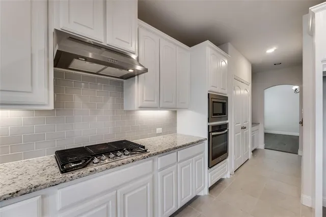 a kitchen with stainless steel appliances granite countertop a sink and a stove